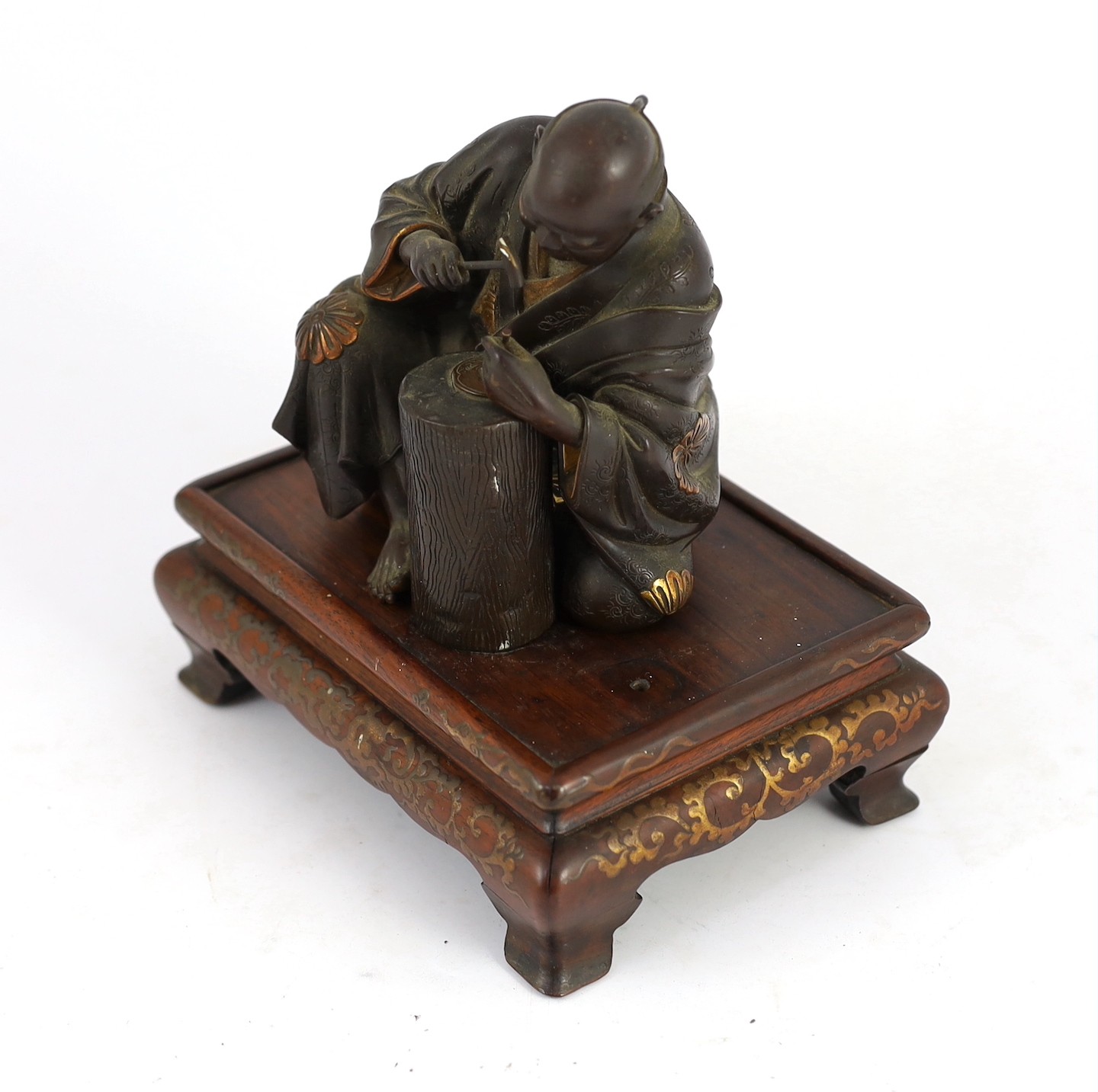 A Japanese bronze model of a sword fittings master craftsman, by Miyao Eisuke, Meiji period, total height 18cm including original gilt lacquered wood stand, small section of bronze lacking